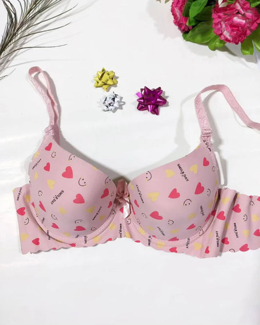 Pink bra with heart patterns on a white background